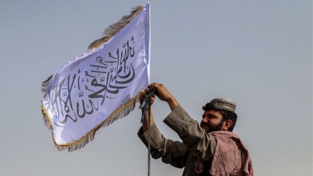 مقاتل من طالبان يرفع علم الحركة