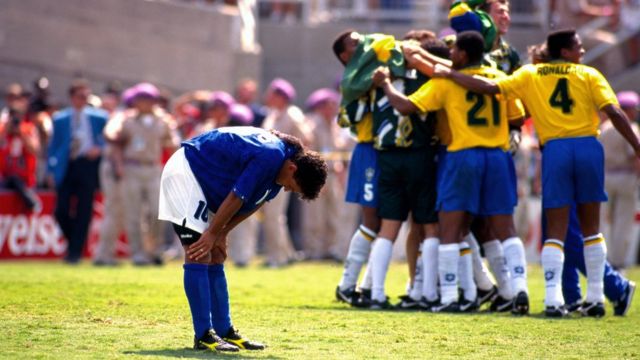 17 July 1994 World Cup Final 1994, Brazil v Italy - Los Angeles, Roberto Baggio has his hands on his knees in despair as the Brazilian team celebrate his missed penalty which won them the world cup