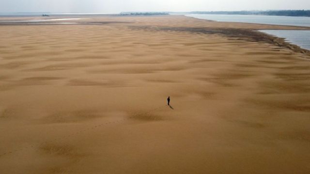 Nesta vista aérea, o ambientalista Luis Martinez caminha ao longo de um banco de areia no Rio Paraná, durante uma seca histórica perto de Paso de la Patria, Corrientes, Argentina, em 20 de agosto de 2021.