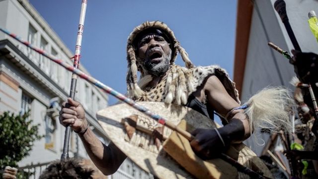 A traditionally dressed Zulu man dances during a gathering in front of a morgue in Johannesburg