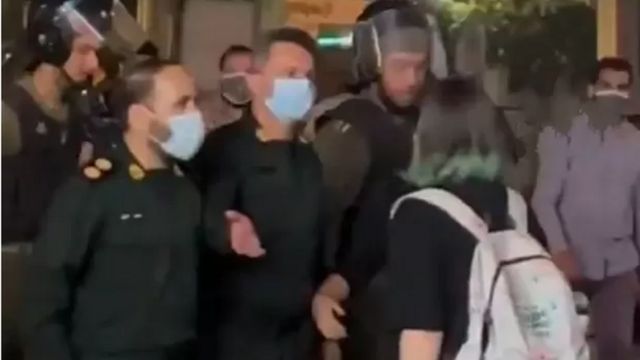 صورة من مقطع فيديو تظهر فيها فتاة تقف أمام مجموعة من قوات الأمن وتتحداهم.