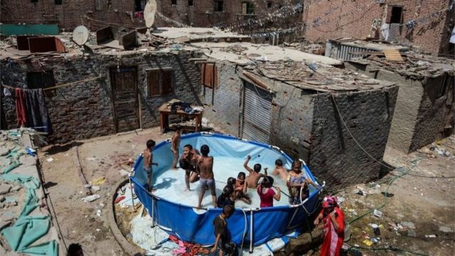 Crianças egípcias brincando em piscina improvisada, em foto de 2015