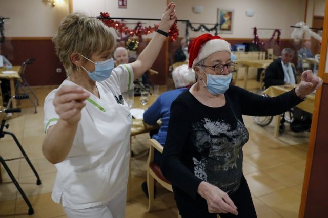 Elderly residents and a nurse celebrate Christmas in Santiago de Compostela, Spain. Photo: 24 December 2020