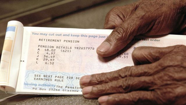 An elderly man holding a pension book