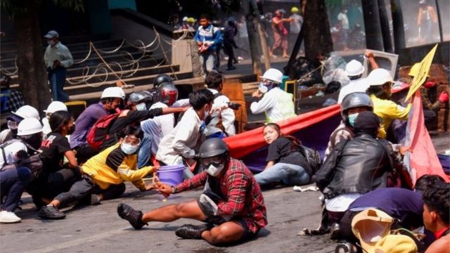 Protesters crouch after police opened fire to disperse a protest against the coup in Mandalay, Myanmar, on March 3, 2021