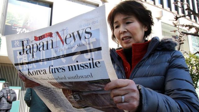 Mulher japonesa lendo jornal