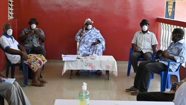 Elders have a meeting about coronavirus at a village in the Ivory Coast