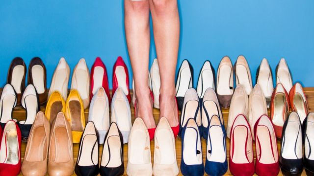 mulher ao redor de diversos pares de sapatos