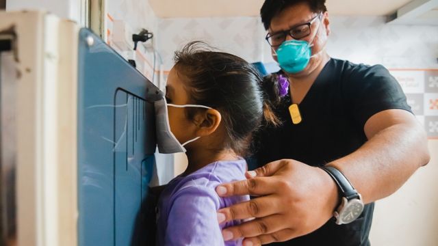 Un médico realiza una placa de tórax a una niña en la clínica TB Móvil de Socios en Salud en Perú