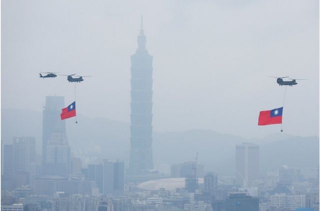 台北举行的双十节庆典期间，悬挂中华民国国旗的支奴干直升机飞过台北101摩天大楼附近。