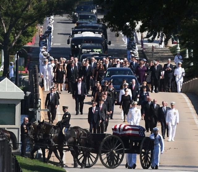 The funeral procession of the late Senator John McCain heads to the cemetery for a private burial at the US Naval Academy in Annapolis