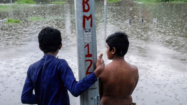 Dos menores observan una zona inundada