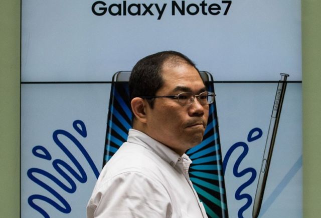 Empleado de Samsung frente a cartel del Galaxy Note7