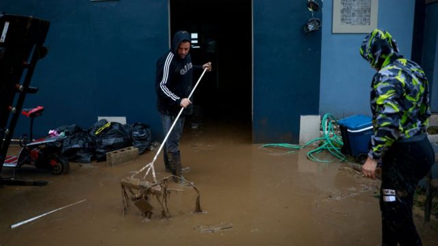 Una persona limpia el lodo en su casa