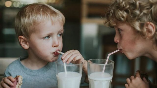 Duas crianças tomando leite