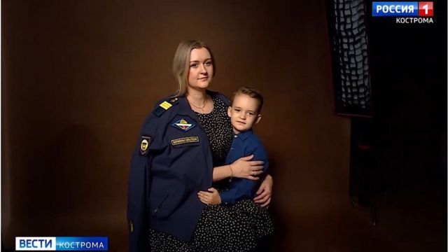 一名俄罗斯士兵的妻子披着他的制服拍照。(photo:BBC)