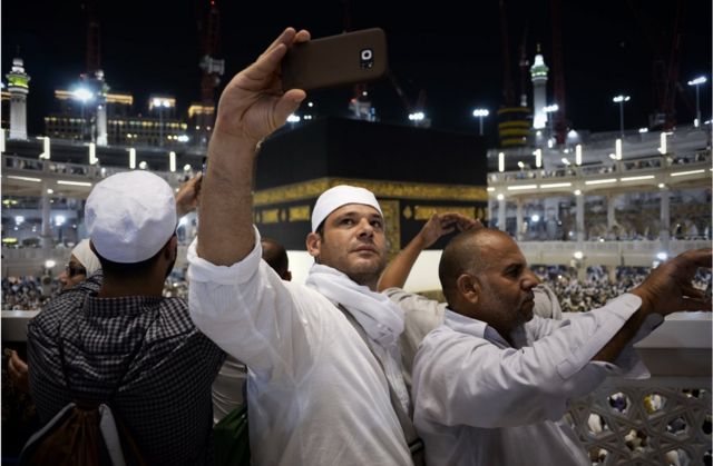 Muslim pilgrims take picture near the Islam's holiest shrine, the Kaaba, at the Grand Mosque in the Saudi holy city of Mecca, late on September 20, 2015. The annual hajj pilgrimage begins on September 22, and more than a million faithful have already flocked to Saudi Arabia in preparation for what will for many be the highlight of their spiritual lives.
