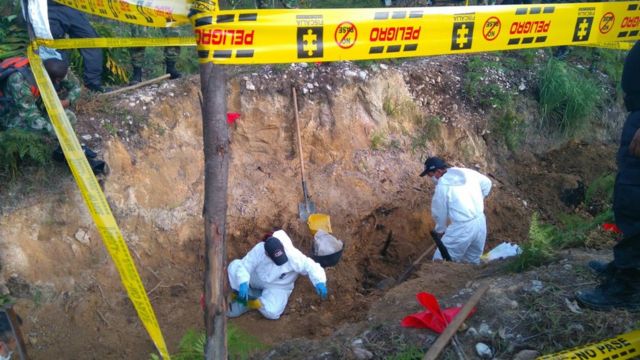 Funcionarios policiales excavan en busca de evidencias.