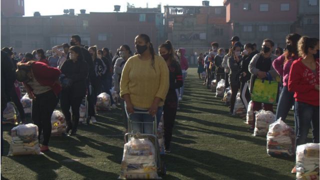Em campo de futebol em Paraisópolis, moradores recebem cestas básicas