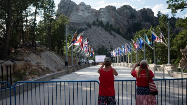 Visitors take pictures of the Mount Rushmore National Monument in Keystone, South Dakota on 2 July