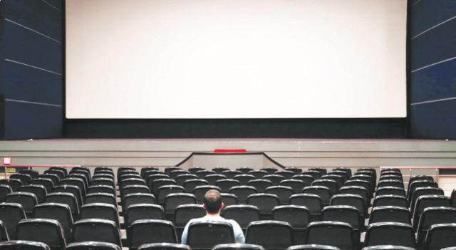 تصویری از سینما با صندلی‌های خالی و یک تماشاگر
