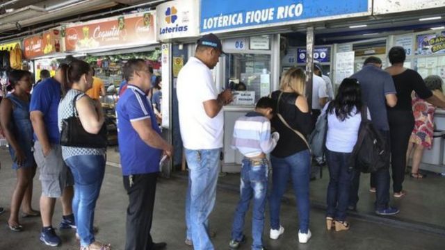 Foto mostra pessoa na fila de lotérica