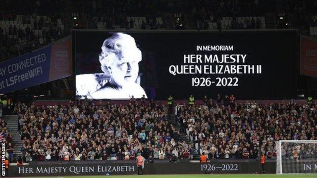  scoreboard at a football ground displaying the phrase "In Memoriam Her Majesty Queen Elizabeth II 1926-2022" and an image of the Queen