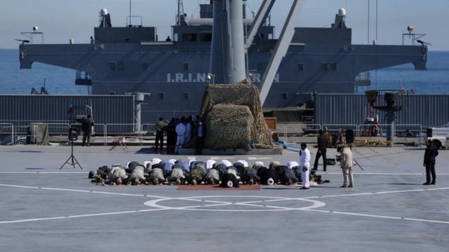 Iranian military commanders offer prayers aboard an Iranian warship before launching maneuvers into the waters of the Gulf of Oman.