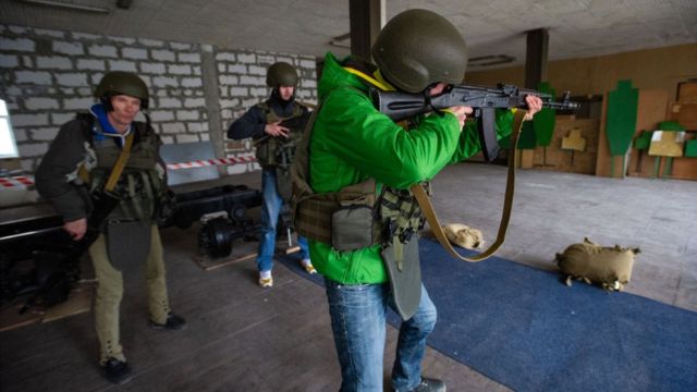 Um ucraniano aprende a manusear um fuzil AK-47, enquanto civis passam por treinamento militar básico em centro de voluntários em uma instituição educacional estatal, em 5 de março de 2022 em Odessa, Ucrânia