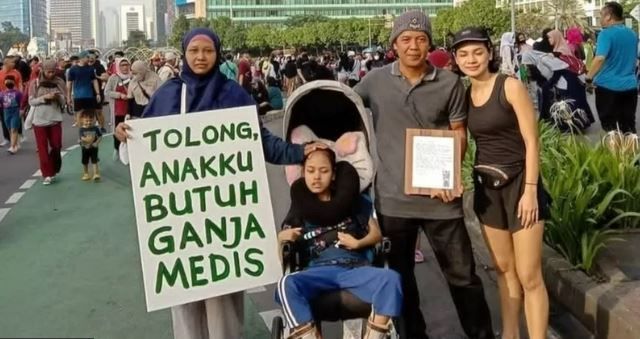 Santi Warastuti dan putrinya, Pika (kiri) menyerukan legalisasi ganja medis pada acara Car Free Day di Jakarta, Minggu (26/06).