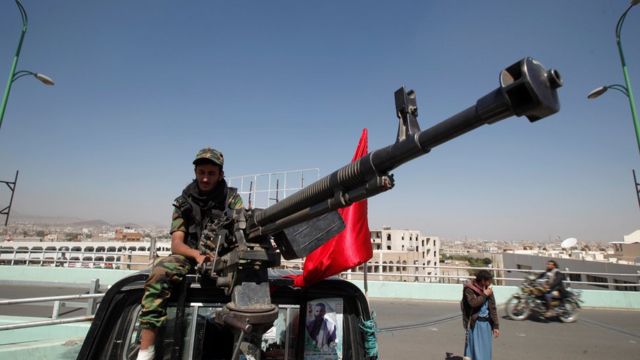 مسلح من الحوثيين يجلس على سيارة ذات دفع رباعي مزودة بمدفع
