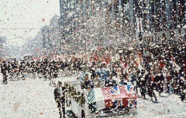 Queen Elizabeth II and Prince Philip in an open car showered with confetti