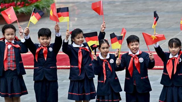 Học sinh Việt Nam vẫy cờ trong lễ đón Thủ tướng Đức Frank-Walter Steinmeier tại Hà Nội, ngày 23/1/2024