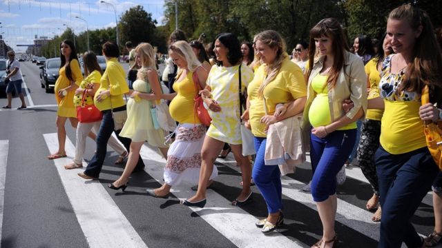 Mujeres embarazadas marchando en fila en las calles.