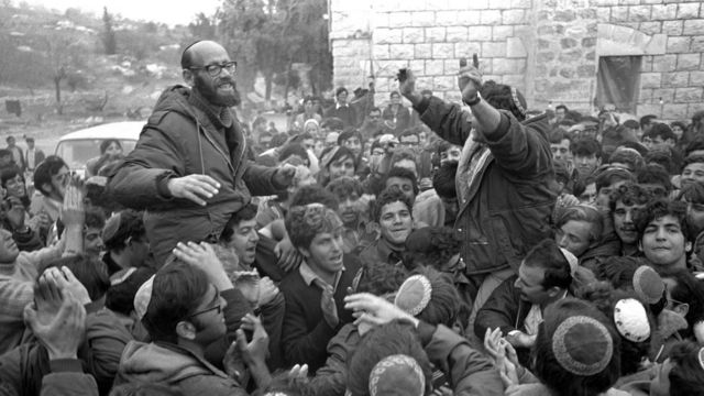 خاخام صهیونیست موشه لوینگر (سمت چپ) افتتاح یک شهرک جدید در کرانه غربی در دهه ۱۹۷۰ را جشن می‌گیرد