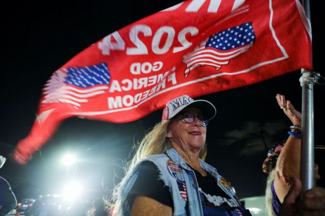 A supporter of former U.S. President Donald Trump attends a gathering outside his Mar-a-Lago resort after hearing news of Trump's indictment by a Manhattan grand jury following a probe into hush money paid to porn star Stormy Daniels, in Palm Beach, Florida, U.S., March 30, 2023. 