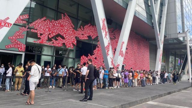 Dòng khách vãng lai đứng xếp hàng đợi đăng ký mua iPhone trước Central World vào sáng 16/9 tại Bangkok