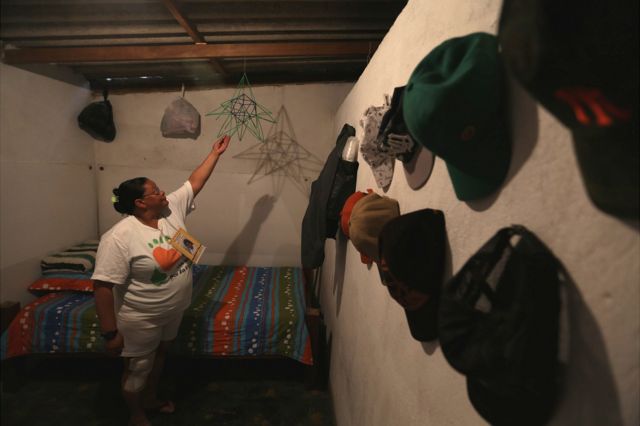 Mujer sostiene un adorno dentro de un cuarto.