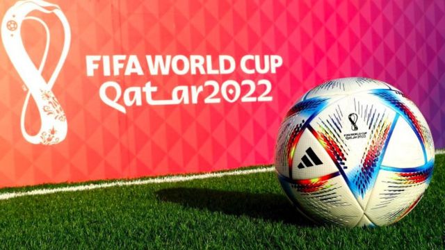 A football in front of a Qatar 2022 logo