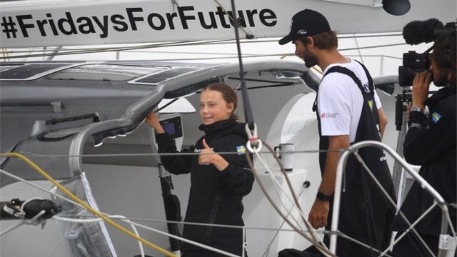 Greta Thunberg gives a thumbs up from her yacht after arriving in New York