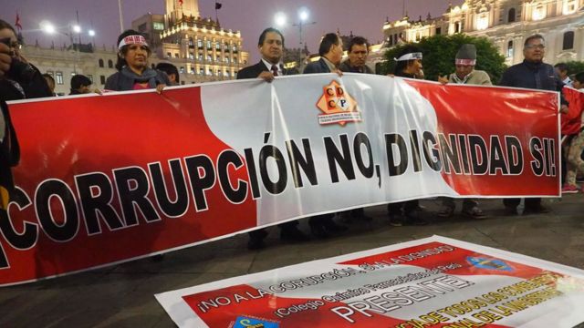 Manifestantes con una pancarta que dice "corrupción no, dignidad sí".
