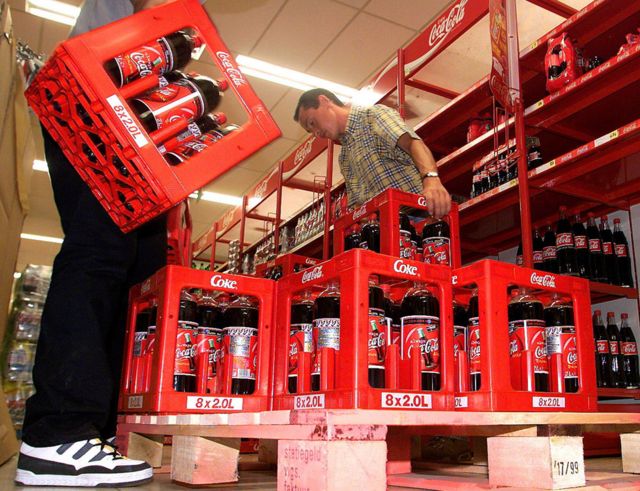 Empleados en Bélgica retiran botellas de Coca-Cola de un supermercado, en junio de 1999.