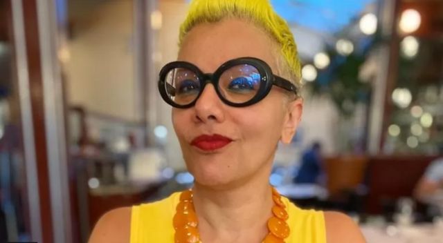 Mulher de batom com cabelo e roupa amarelos
