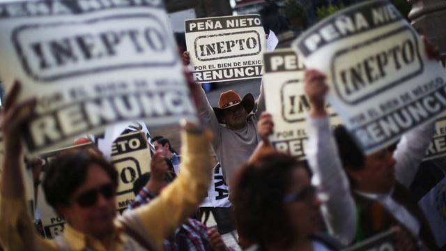 Manifestantes con pancartas solicitando la renuncia de Peña Nieto.