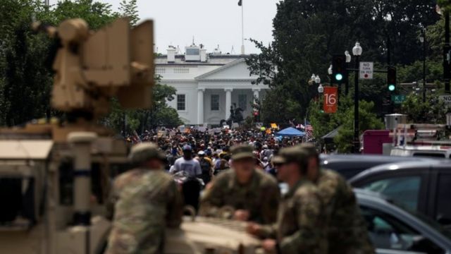 Manifestantes cerca de la Casa Blanca, en Washington D.C., siendo vigilados por soldados.