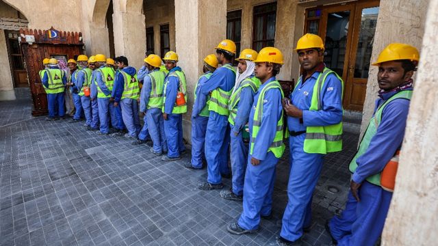 Trabajadores migrantes en Doha, Qatar, haciendo fila para usar un cajero automático