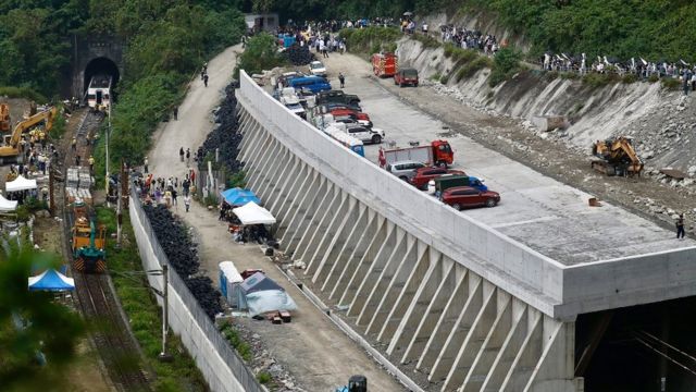 Relatives of victims grief as they pray near the site where a train derailed in a tunnel north of Hualien County, eastern Taiwan, 03 April 2021