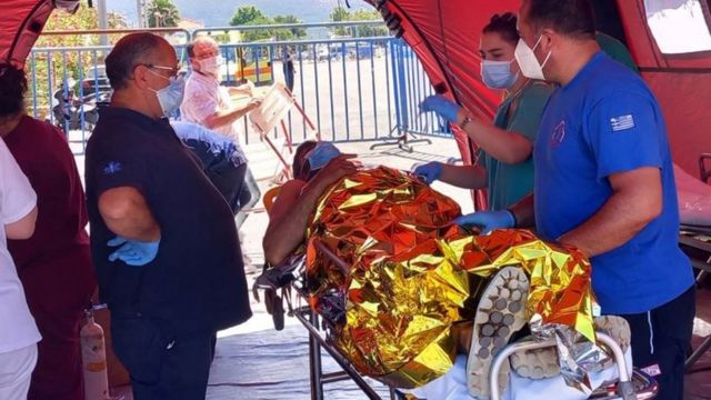 Paramedics help migrants upon arrival to Kalamata port