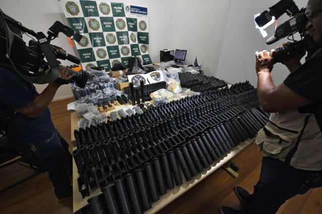 Armas automticas, dinheiro e outros equipamentos apreendidos na casa de um amigo do sargento da Polcia Militar Ronnie Lessa - preso em conexo com o assassinato da vereadora e ativista do Rio de Janeiro Marielle Franco - so exibidos na sede da Polcia Civil no Rio de Janeiro, Brasil, em 12 de maro de 2019. (Foto de CARL DE SOUZA / AFP) (Crdito da foto deve ser CARL DE SOUZA/AFP via Getty Images)