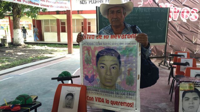 Margarito Guerrero muestra un cartel con el rostro de Jhosivani Guerrero de la Cruz, uno de los 43 estudiantes desaparecidos.